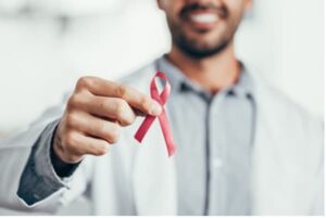 Zoom in photo of man holding HIV awareness ribbon.