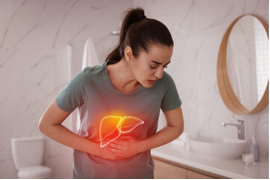 A woman clutching stomach in liver pain.